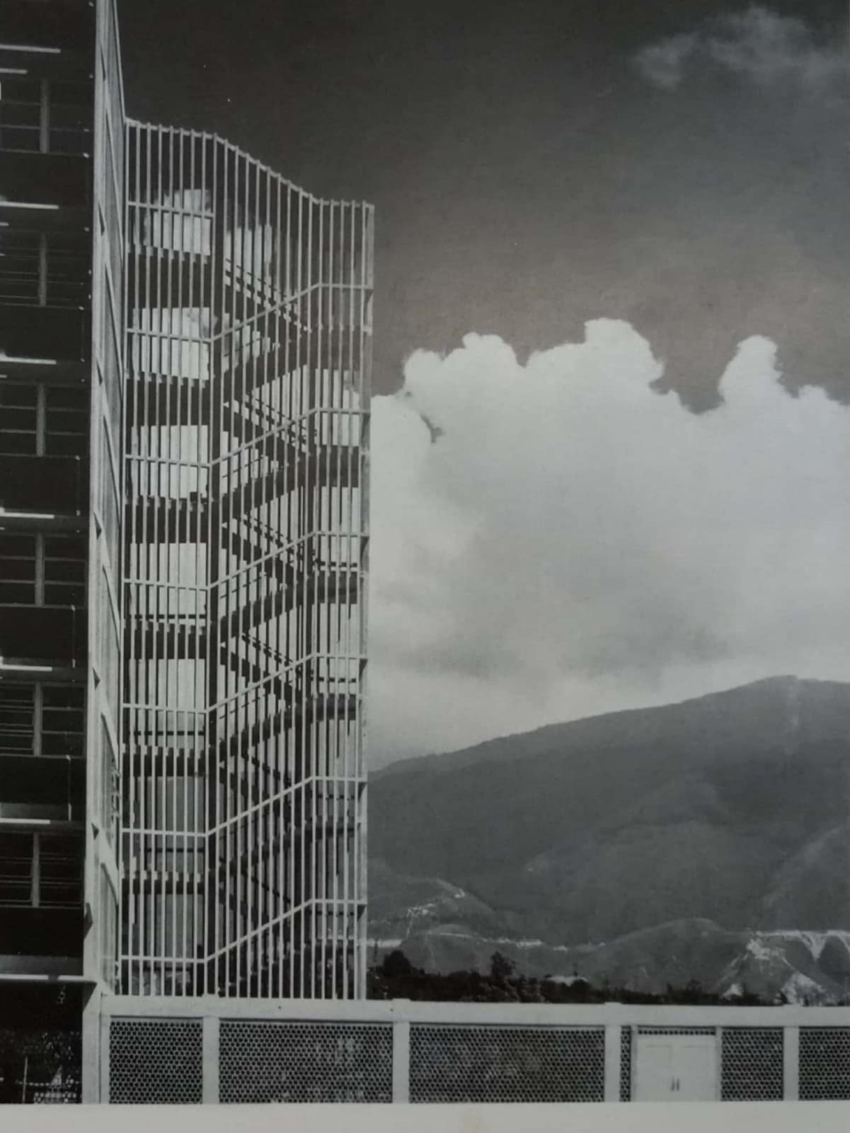 Torre de escaleras con brise-soleil de la Escuela de Farmacia de la Ciudad Universitaria, recortada contra El Ávila y las nubes